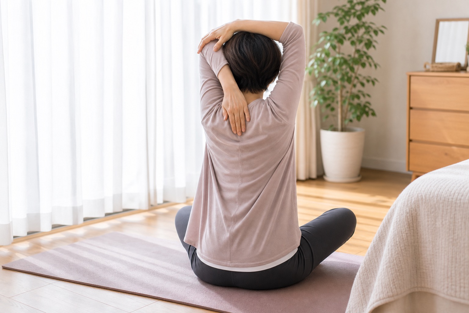 自宅でストレッチをする女性の後ろ姿